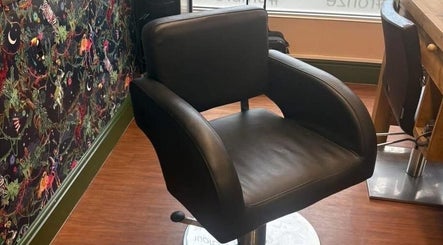 Stylish salon chair at Naughtycornerhairco, Saint Leonards, England, GB, next to vibrant, patterned wall.
