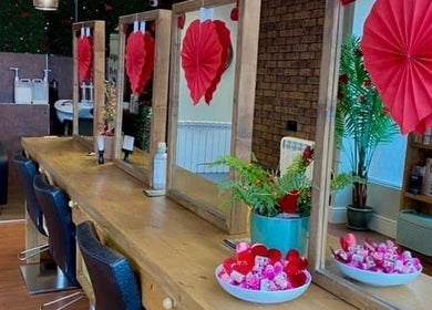 Elegant salon interior at Naughtycornerhairco, Saint Leonards, England, GB, with decorative red accents.