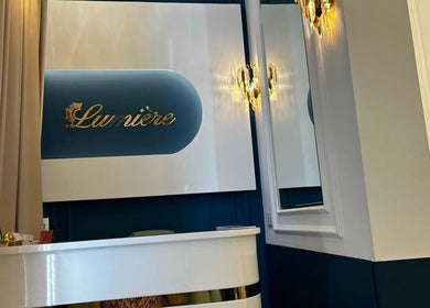 Elegant reception area of Lumiere Ladies Salon in Dubai, AE, featuring warm lighting and sophisticated decor.