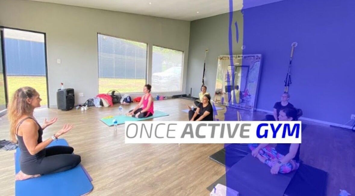 Yoga class at Once Active Gym, Sandton, Gauteng, ZA with people seated on mats in a serene studio.