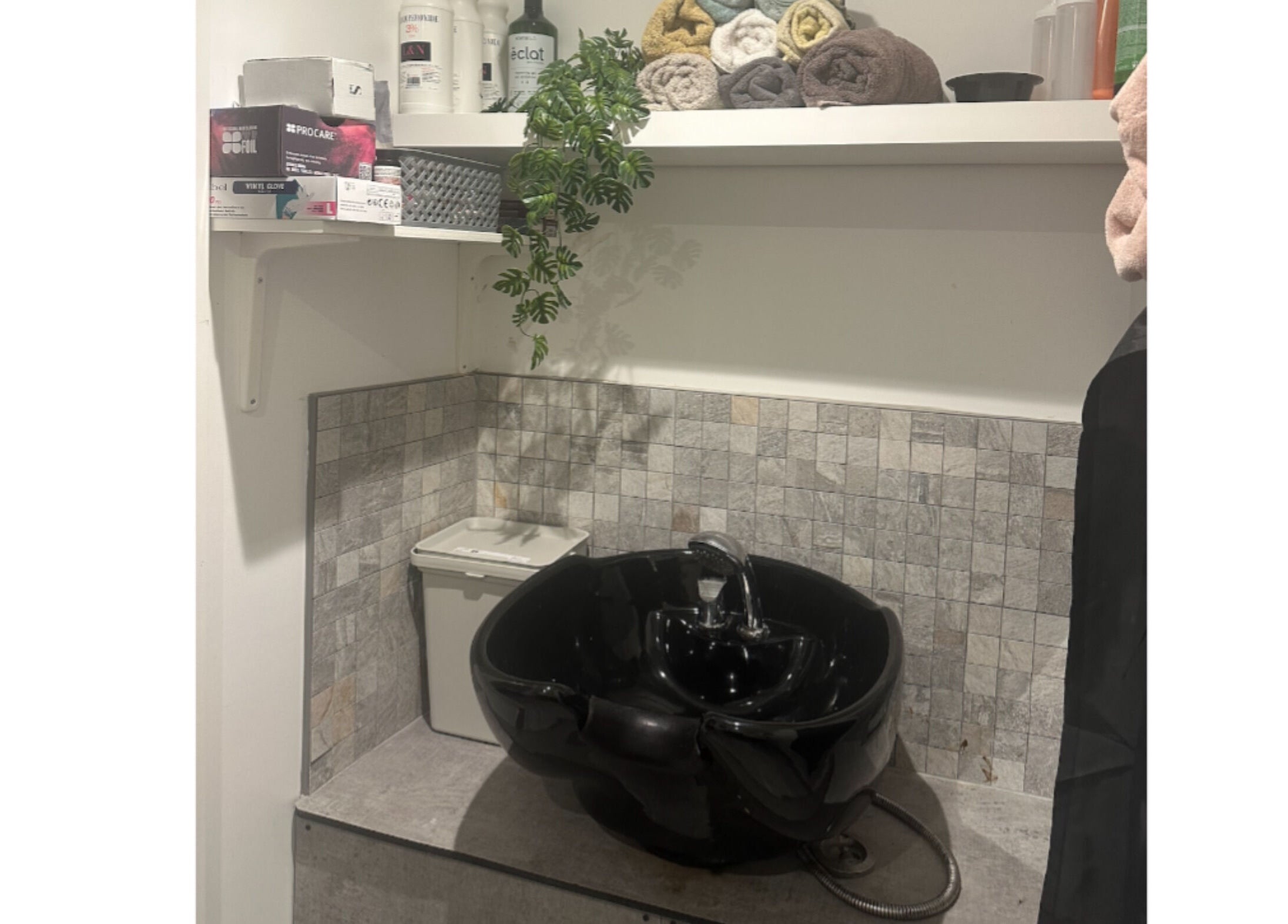 Elegant wash station at Hair.by.kitty, Bletchley, England, GB, featuring a chic black basin and stylish decor.