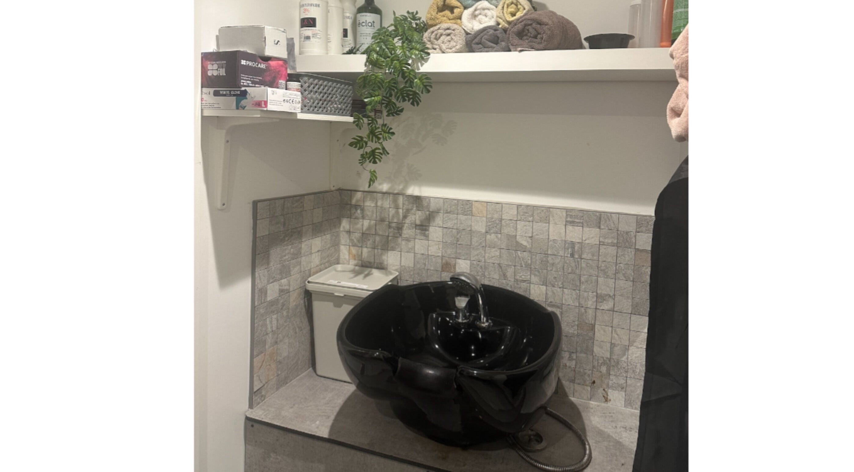 Elegant wash station at Hair.by.kitty, Bletchley, England, GB, featuring a chic black basin and stylish decor.