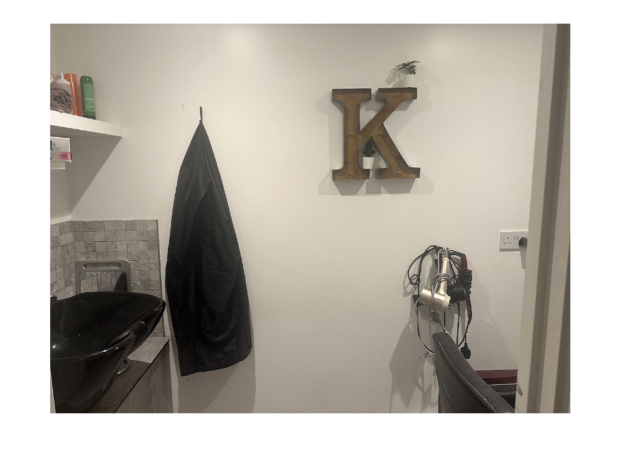 Modern salon setup at Hair.by.kitty in Bletchley, England, GB, featuring black sink and styling tools.