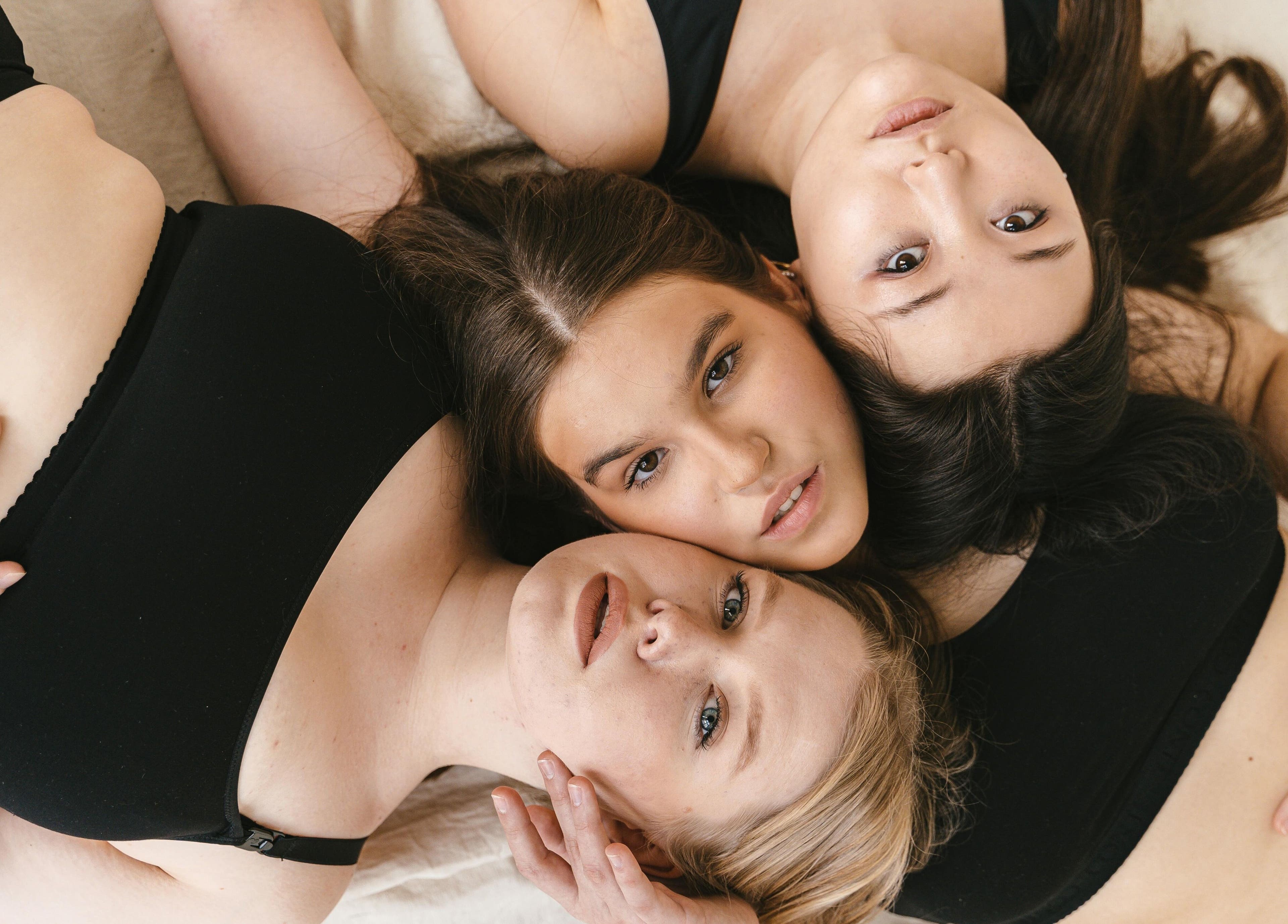 Three women embracing in black attire at Permake Studio, Providencia, Región Metropolitana, CL.