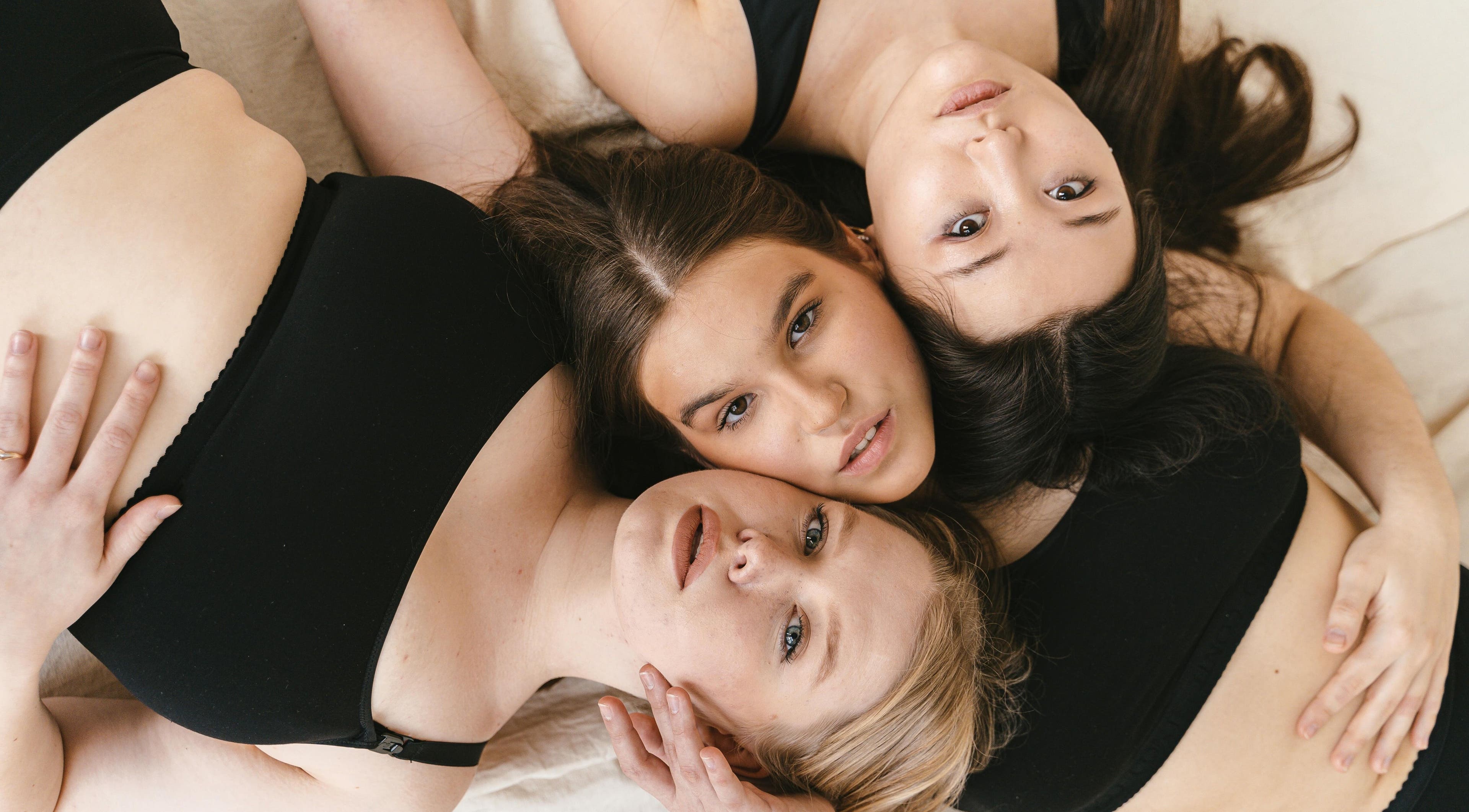 Three women embracing in black attire at Permake Studio, Providencia, Región Metropolitana, CL.