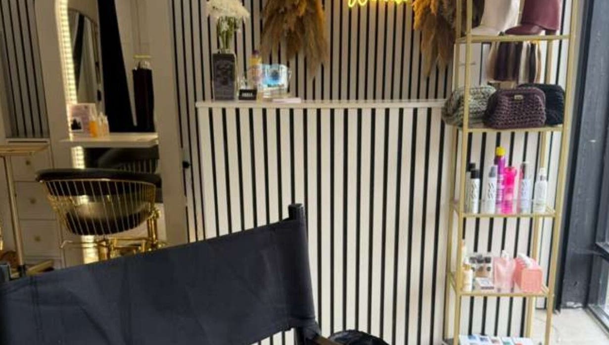 Elegant interior of Marriage Material Make up, Dartford, England, GB with stylish chair and product shelf.