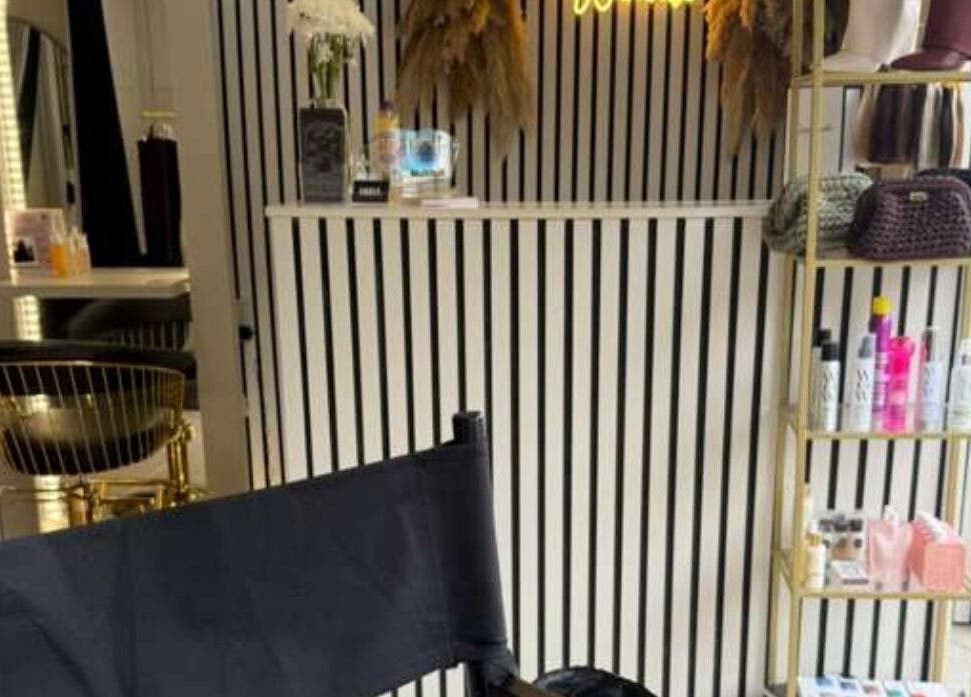 Elegant interior of Marriage Material Make up, Dartford, England, GB with stylish chair and product shelf.