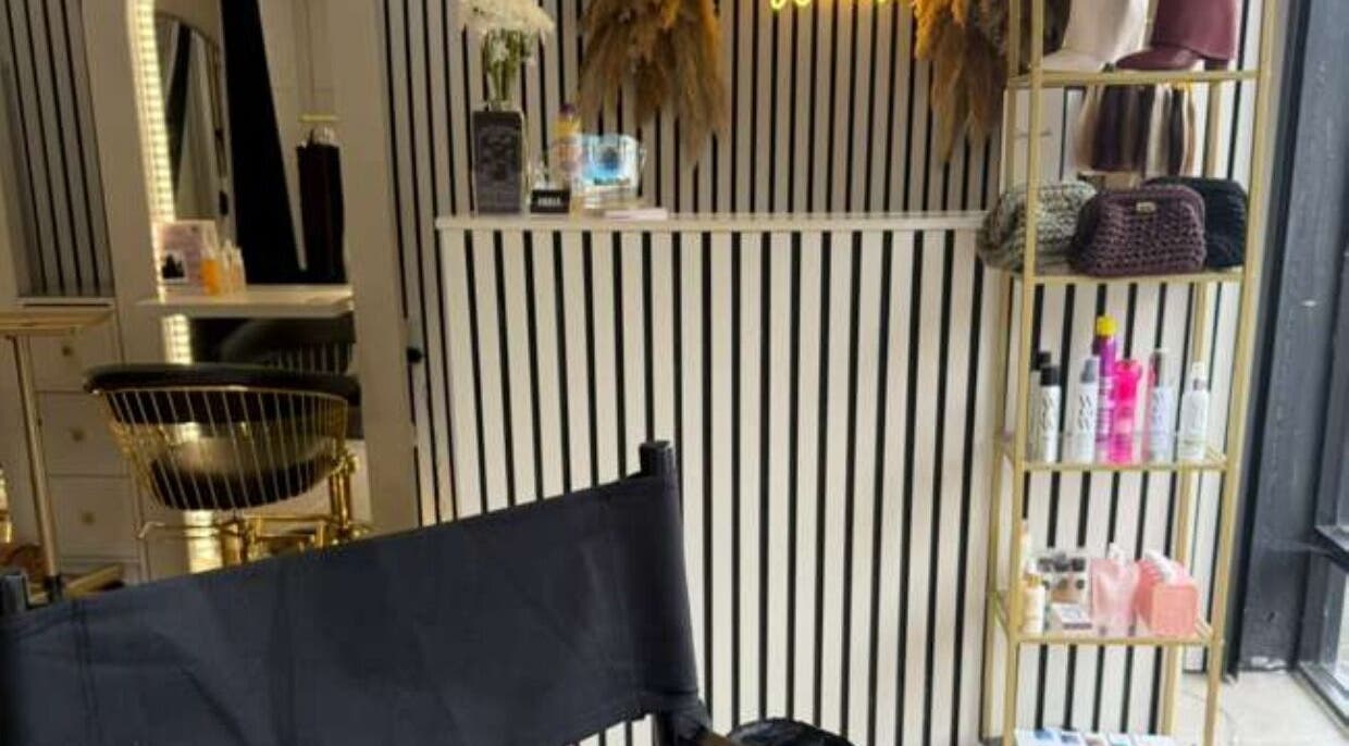 Elegant interior of Marriage Material Make up, Dartford, England, GB with stylish chair and product shelf.