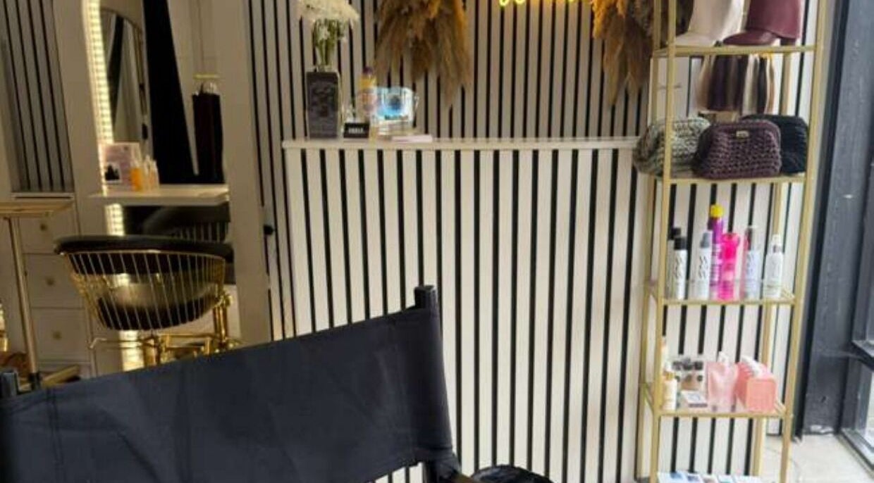 Elegant interior of Marriage Material Make up, Dartford, England, GB with stylish chair and product shelf.