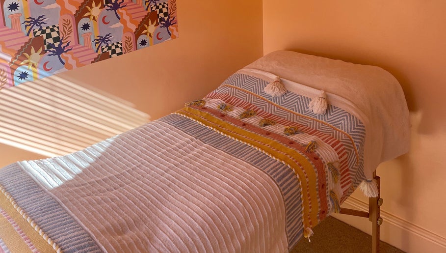 Serene treatment room at Sole Therapy Wirral, Wallasey, with a colorful blanket on a massage bed.