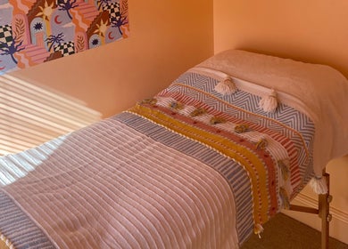 Serene treatment room at Sole Therapy Wirral, Wallasey, with a colorful blanket on a massage bed.