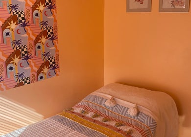 Cozy treatment room at Sole Therapy Wirral in Wallasey, England with colorful decor and a comfortable bed.