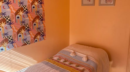 Cozy treatment room at Sole Therapy Wirral in Wallasey, England with colorful decor and a comfortable bed.