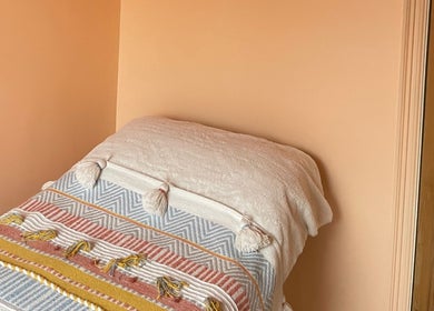 Relaxing treatment room at Sole Therapy Wirral, Wallasey, England, GB with soft pastel walls and cozy bed.