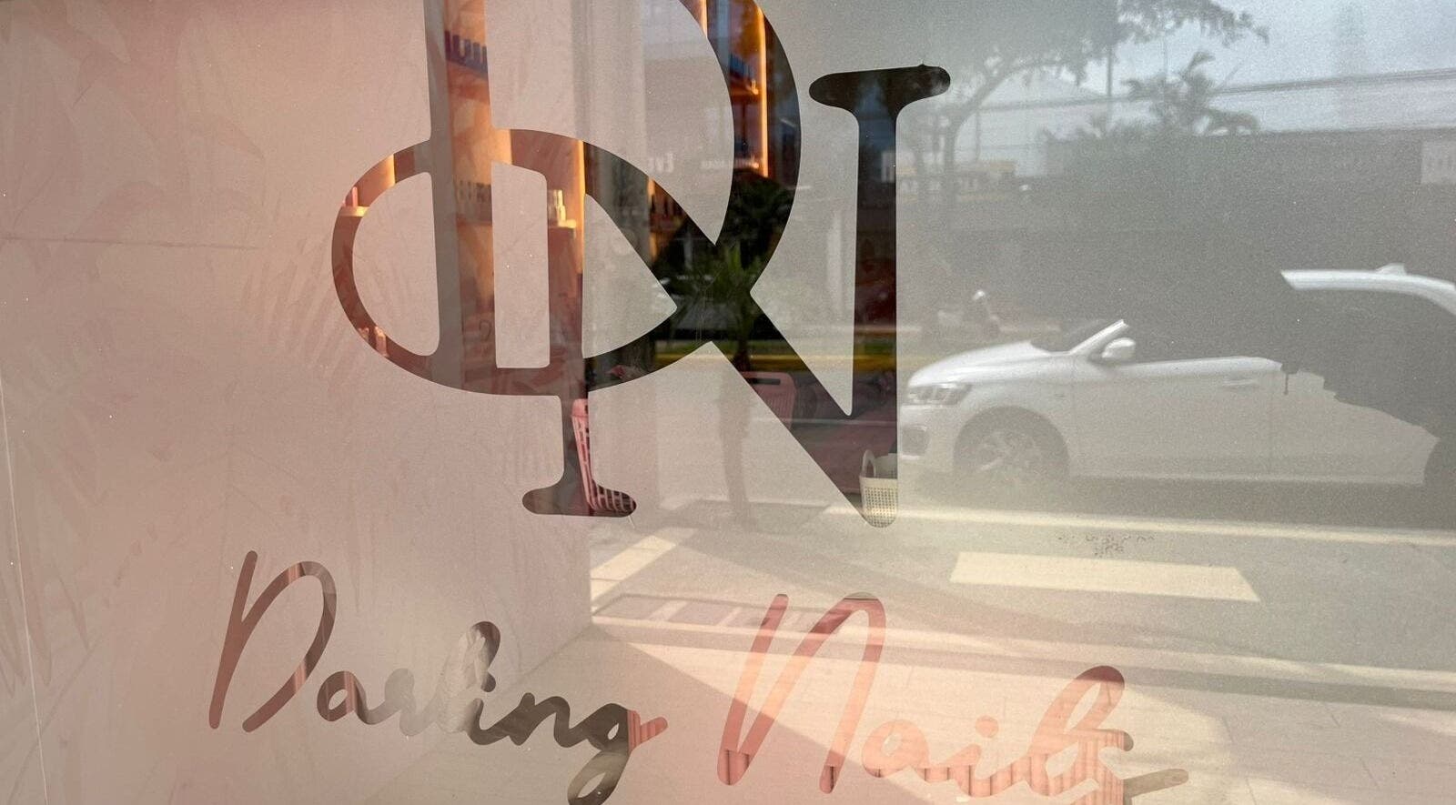 Vista del logo de DARLING NAILS reflejado en la ventana en Portoviejo, Manabí, EC.