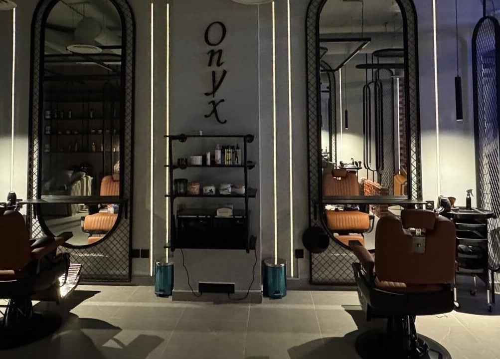 داخل صالون Onyx cuts الرياض, منطقة الرياض, SA يظهر مقعدين فاخرة وجدار مرايا.