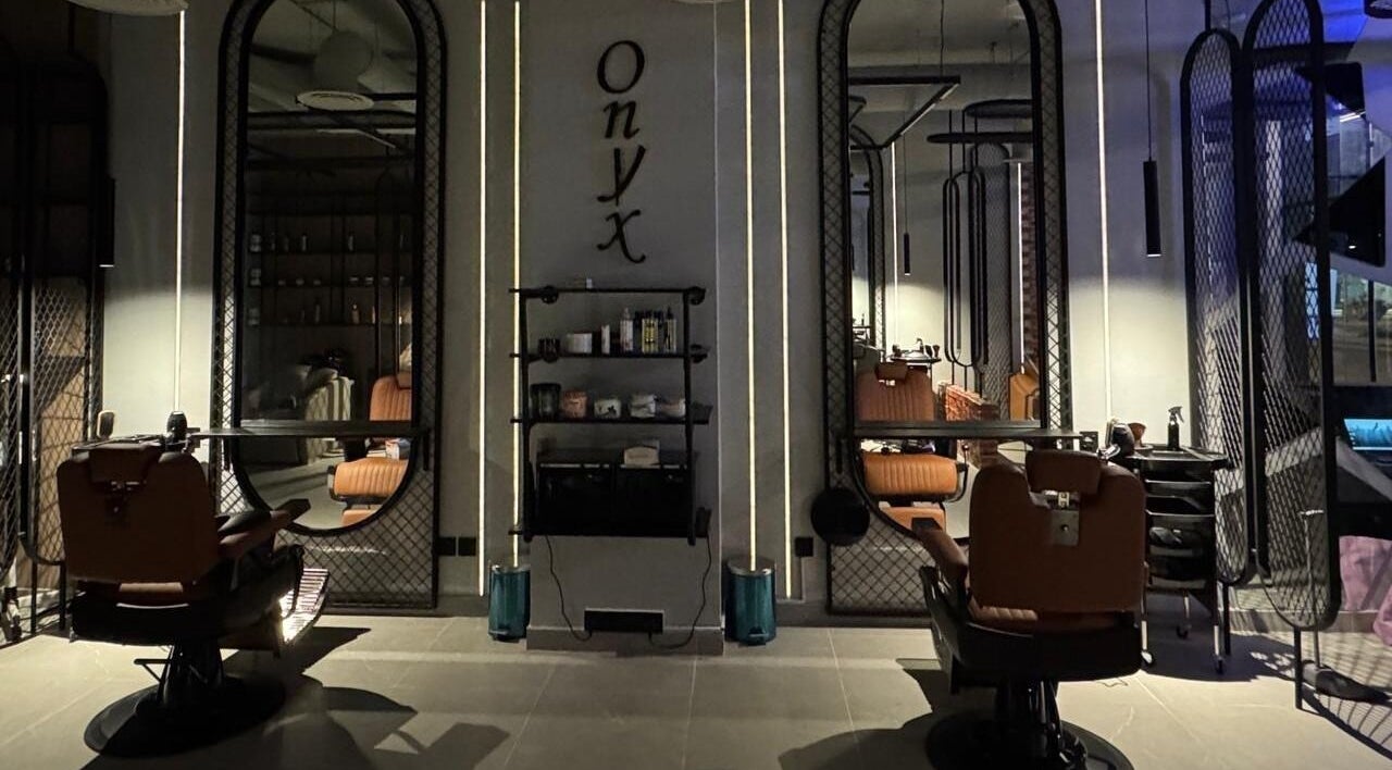 داخل صالون Onyx cuts الرياض, منطقة الرياض, SA يظهر مقعدين فاخرة وجدار مرايا.
