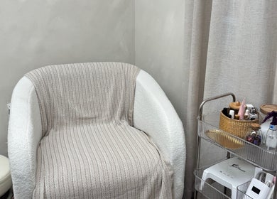 Espacio acogedor en AMAR Nails Studio, Miami, Florida, US con silla y carrito de belleza.