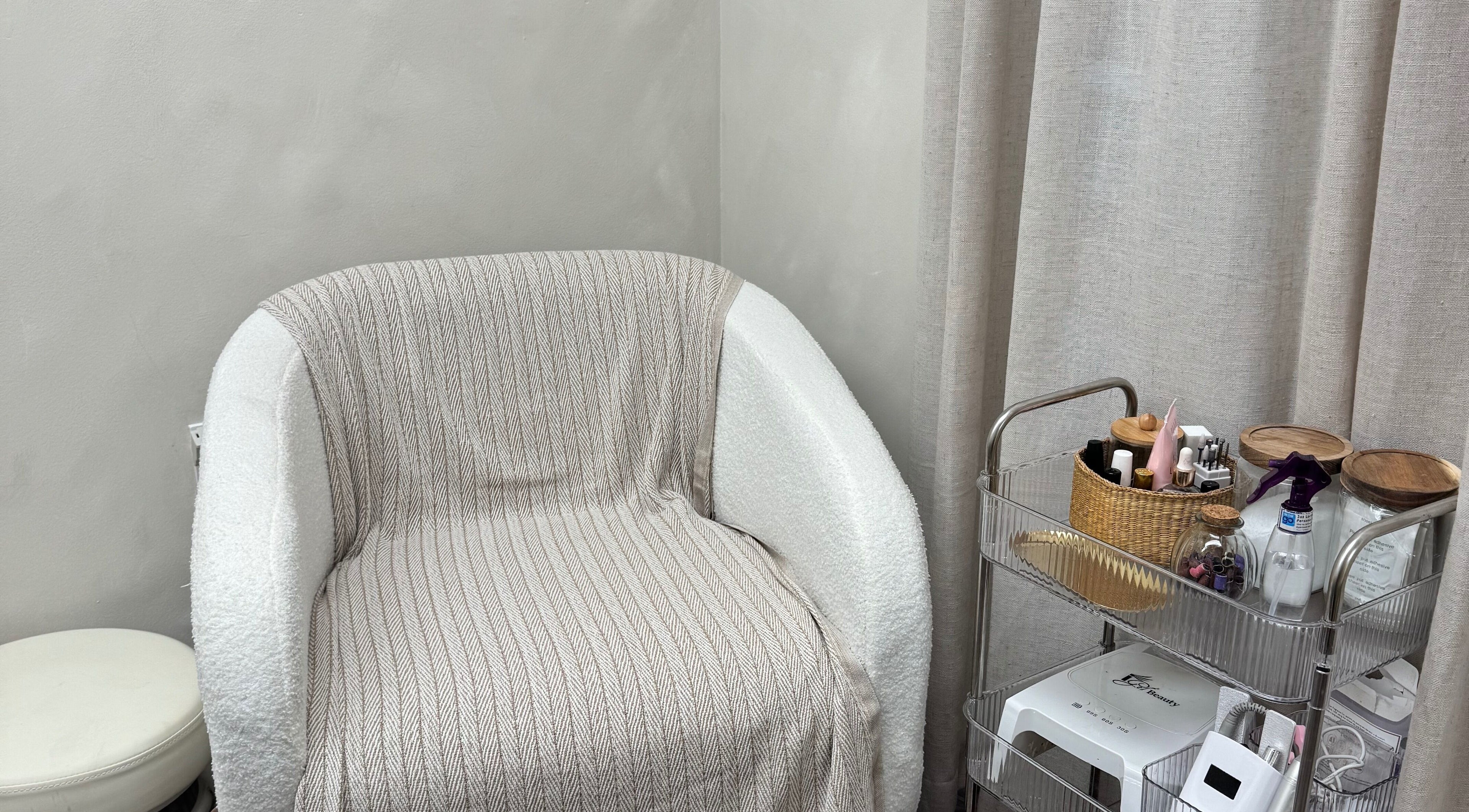 Espacio acogedor en AMAR Nails Studio, Miami, Florida, US con silla y carrito de belleza.