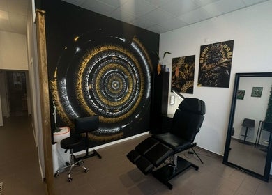 Interior moderno do Sorry Mom Studio em Fátima, Santarém, PT com cadeira de estética e mural artístico.