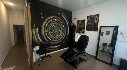 Interior moderno do Sorry Mom Studio em Fátima, Santarém, PT com cadeira de estética e mural artístico.