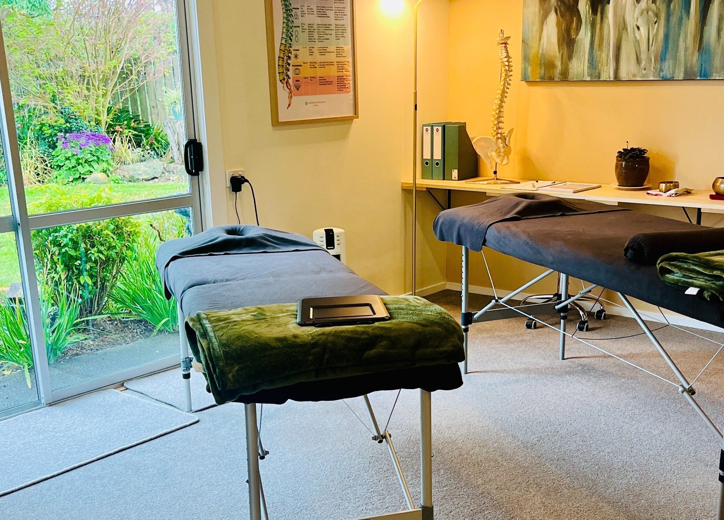 Relaxing therapy room at Omega Wellness, Waimate North, Northland Region, NZ with massage tables and garden view.