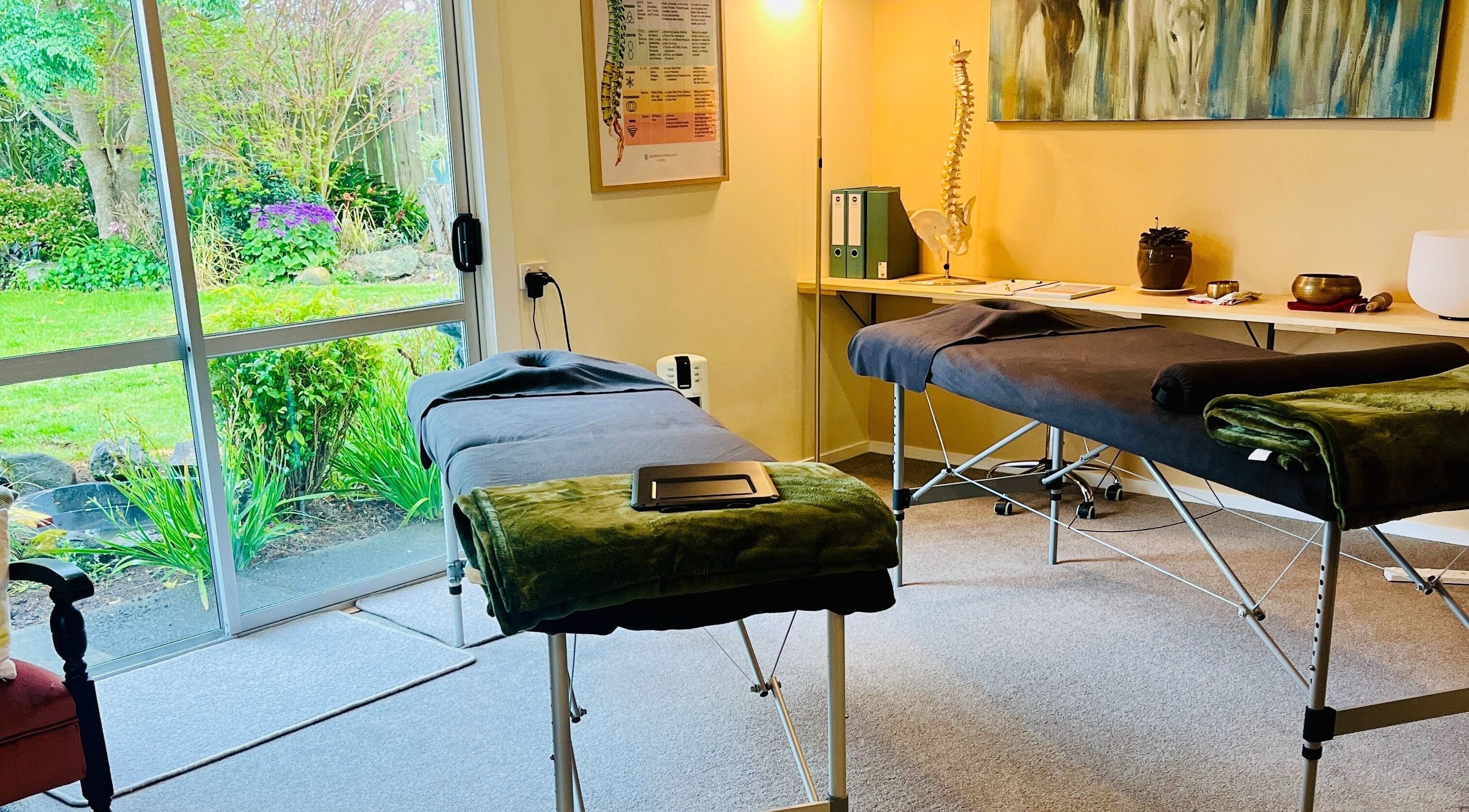 Relaxing therapy room at Omega Wellness, Waimate North, Northland Region, NZ with massage tables and garden view.