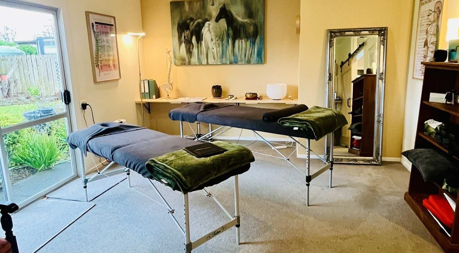 Massage room at Omega Wellness, Waimate North, Northland Region, NZ with twin treatment tables and serene decor.