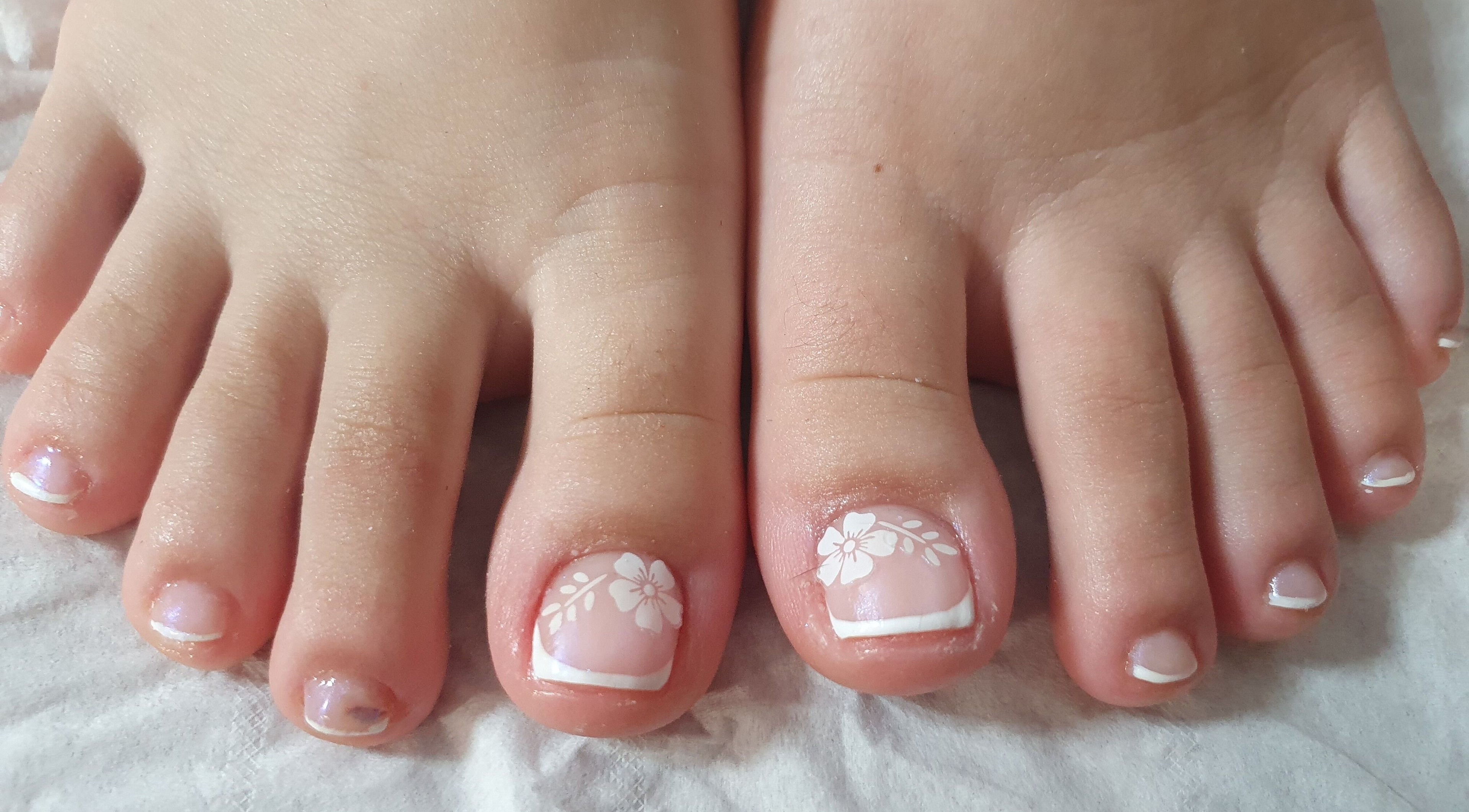 Decoración de uñas de pies con flores blancas en Erika nails, Newry, GB.
