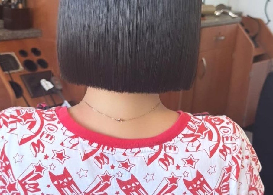 Sleek bob hairstyle at Jing Zhou salon, San Mateo, California, US. Modern salon chair and styling tools visible.