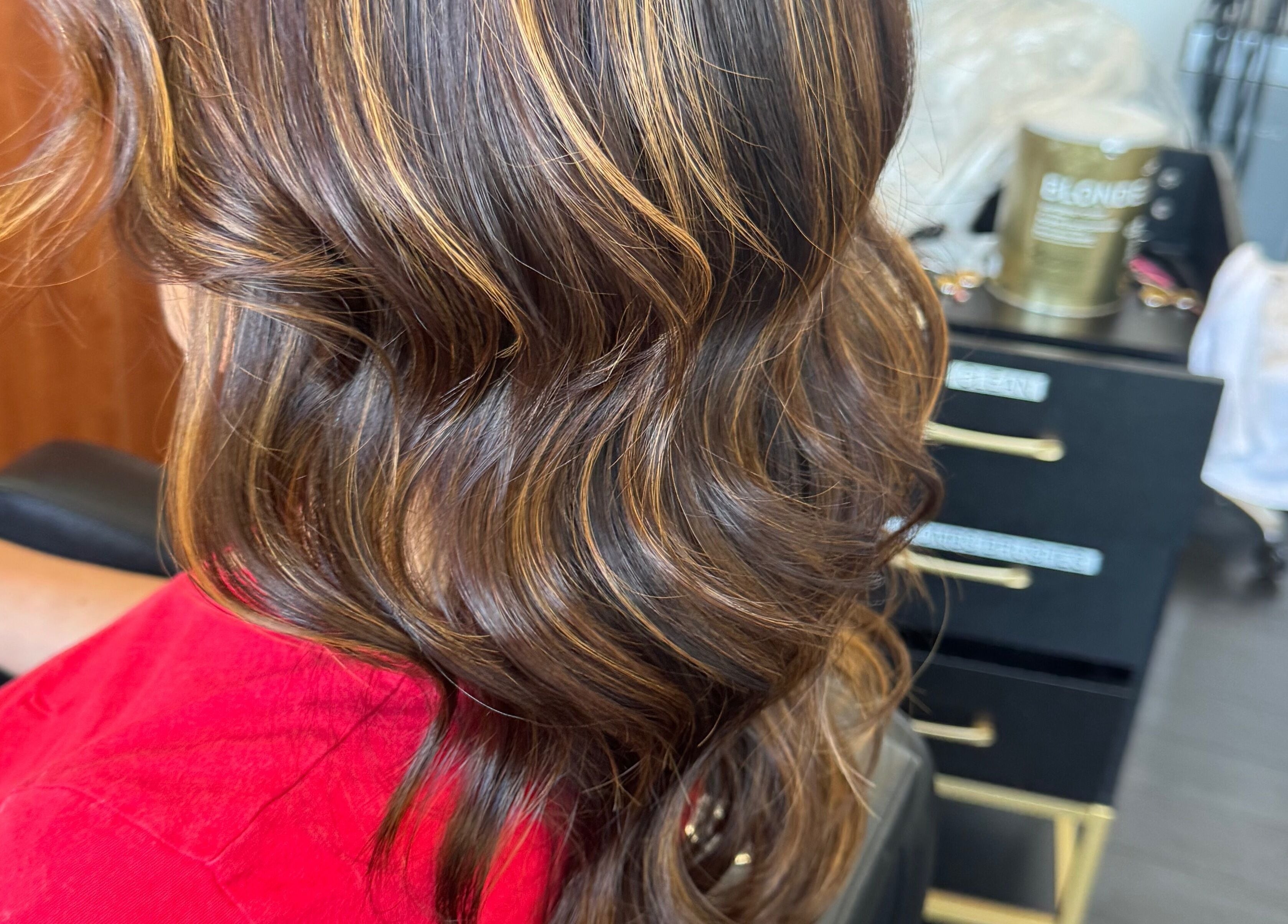 Highlighted curly hairstyle at Jing Zhou salon in San Mateo, California, US, showcasing rich brown tones.