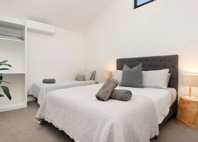 Tranquil guest room at Port Fairy Day Spa, Port Fairy, Victoria, AU with plush beds and soft lighting.