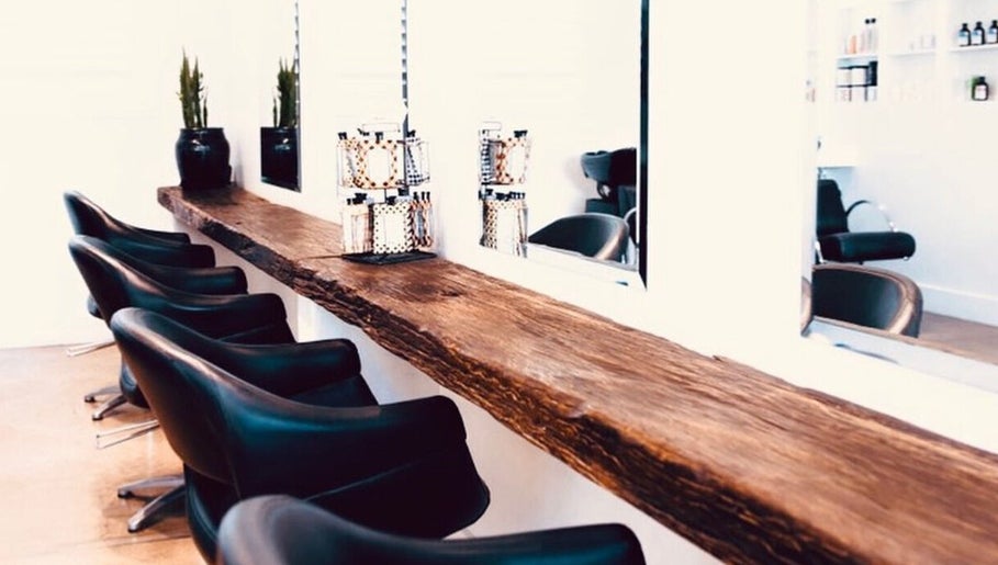 Sleek salon chairs and rustic counter at Mana Hair, Avalon Beach, NSW, AU, offering a cozy beauty experience.