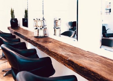 Sleek salon chairs and rustic counter at Mana Hair, Avalon Beach, NSW, AU, offering a cozy beauty experience.