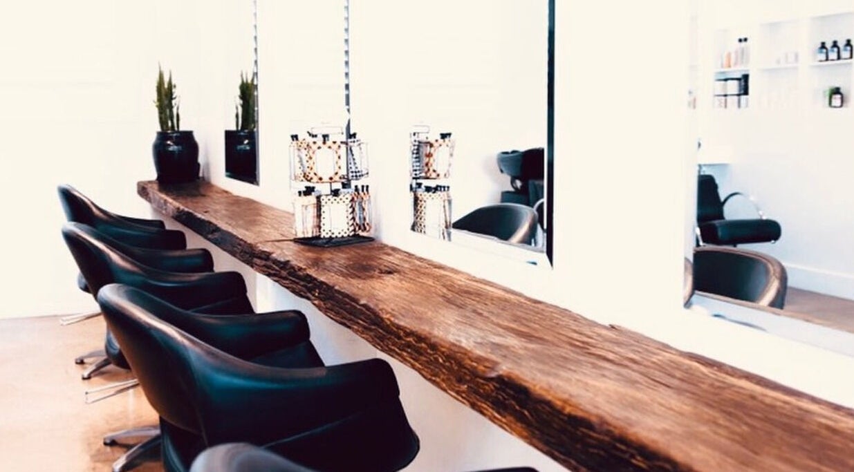 Elegant hair salon seating at Mana Hair in Avalon Beach, NSW, AU with modern decor and wooden countertop.