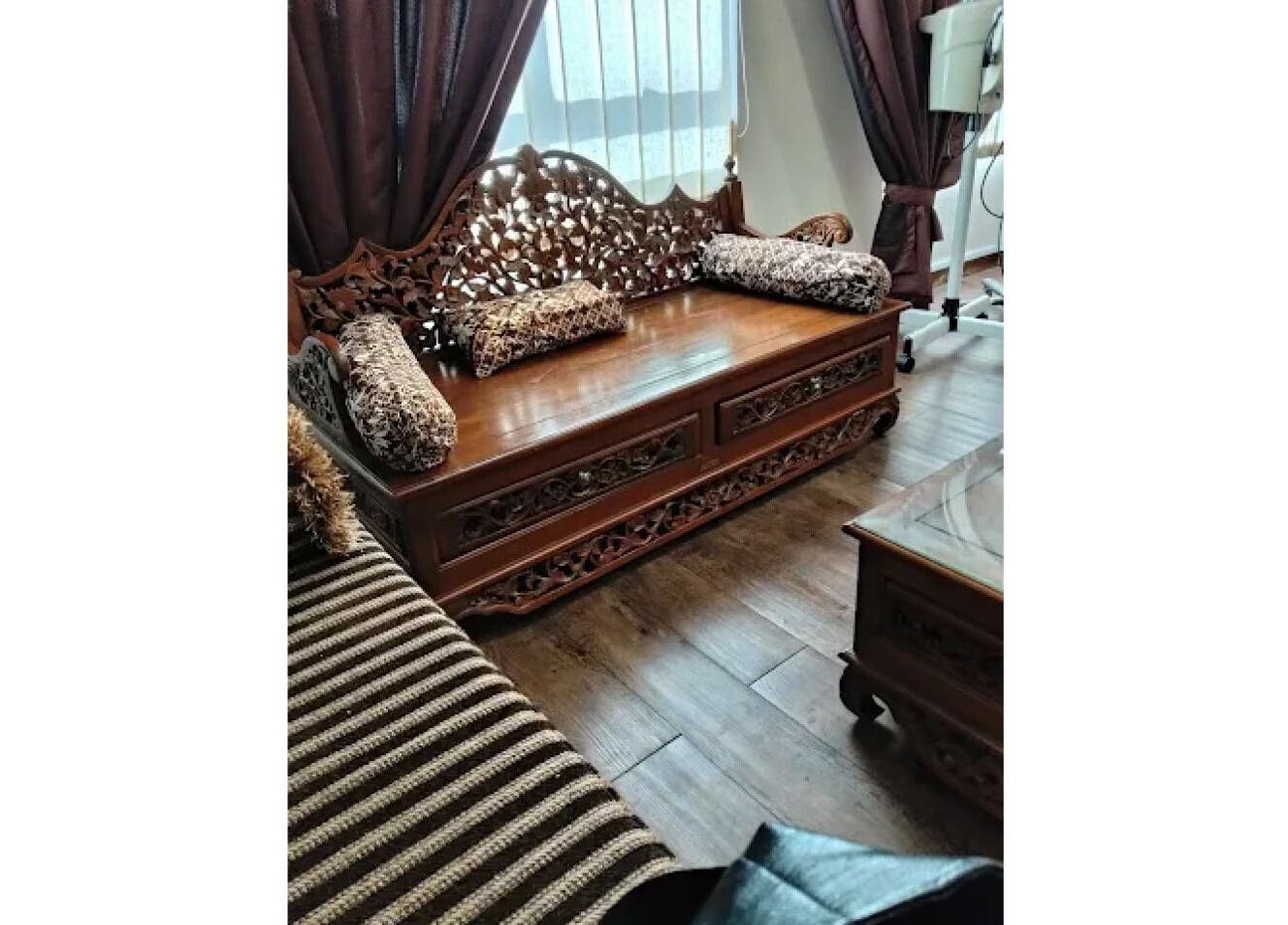 Wooden ornate sofa at Akma Spa, Semenyih, Selangor, MY with luxurious cushions creating a serene atmosphere.