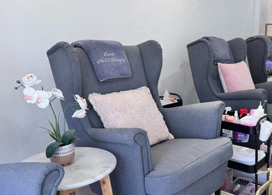 Comfortable salon chairs at Luna Nails & Beauty, Southport, Queensland, AU, with plush pillows and vibrant orchids.