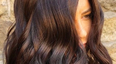 Close-up of sleek brown hair styled in waves at Hairbylianne, Leeds, England, GB.