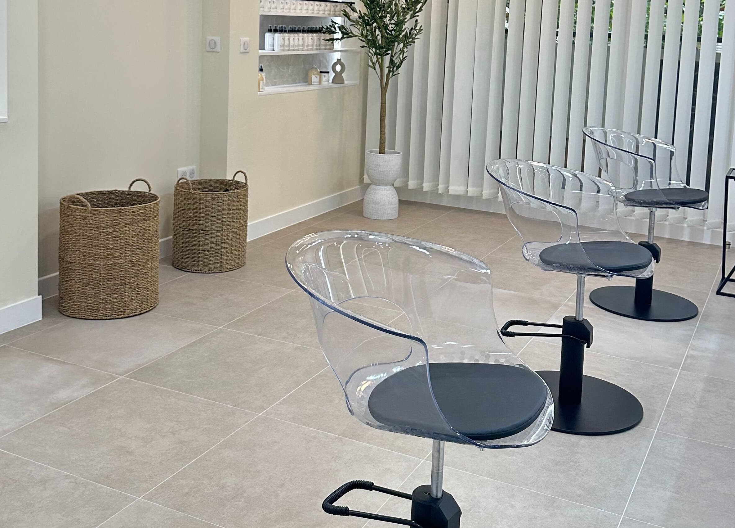 Intérieur moderne du STUDIO CAPILLAIRE à Suresnes, Île-de-France, FR avec chaises transparentes et décoration minimaliste.