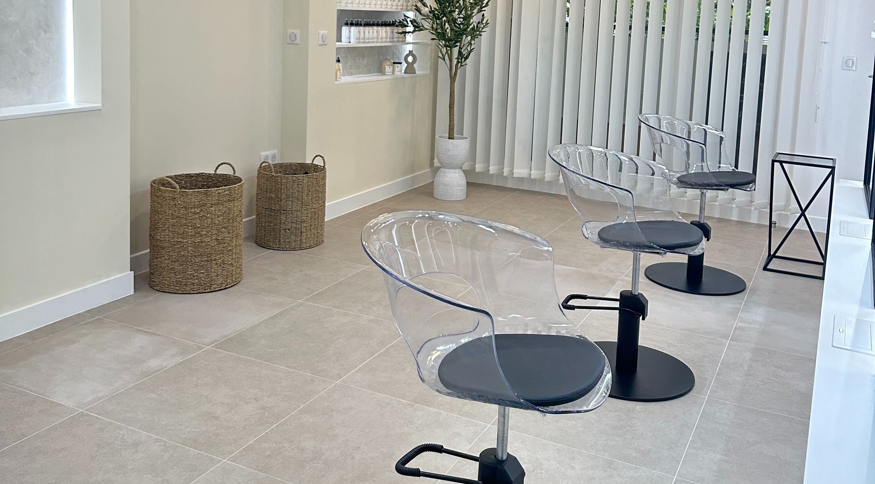Intérieur moderne du STUDIO CAPILLAIRE à Suresnes, Île-de-France, FR avec chaises transparentes et décoration minimaliste.