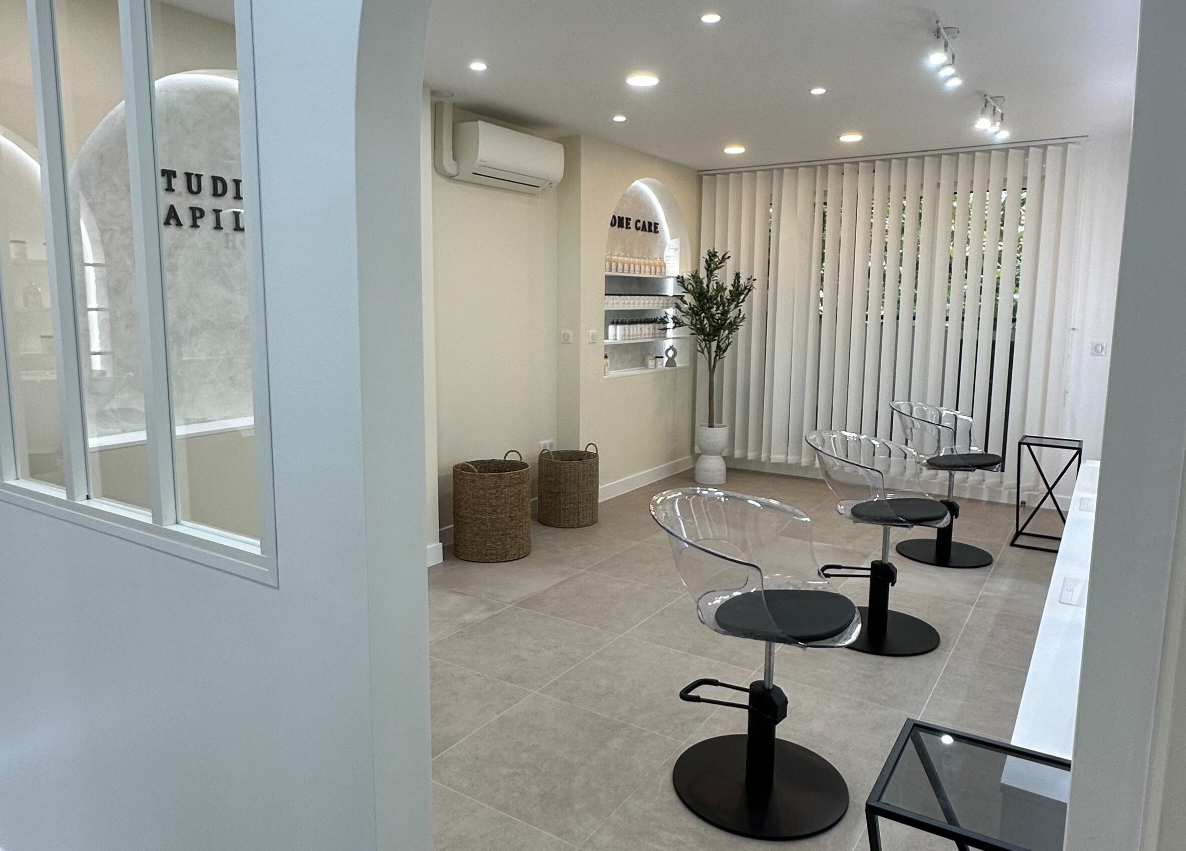 Intérieur moderne de STUDIO CAPILLAIRE à Suresnes, Île-de-France, FR avec sièges élégants et déco minimaliste.