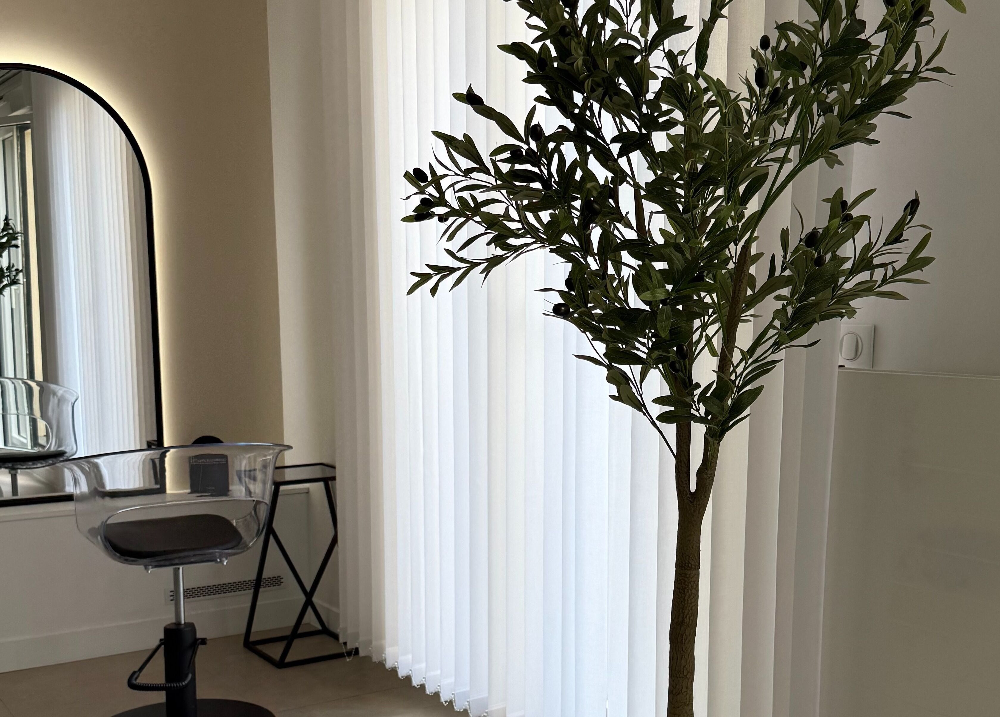 Intérieur élégant de STUDIO CAPILLAIRE à Suresnes, Île-de-France, FR avec miroir rétroéclairé et chaise moderne.