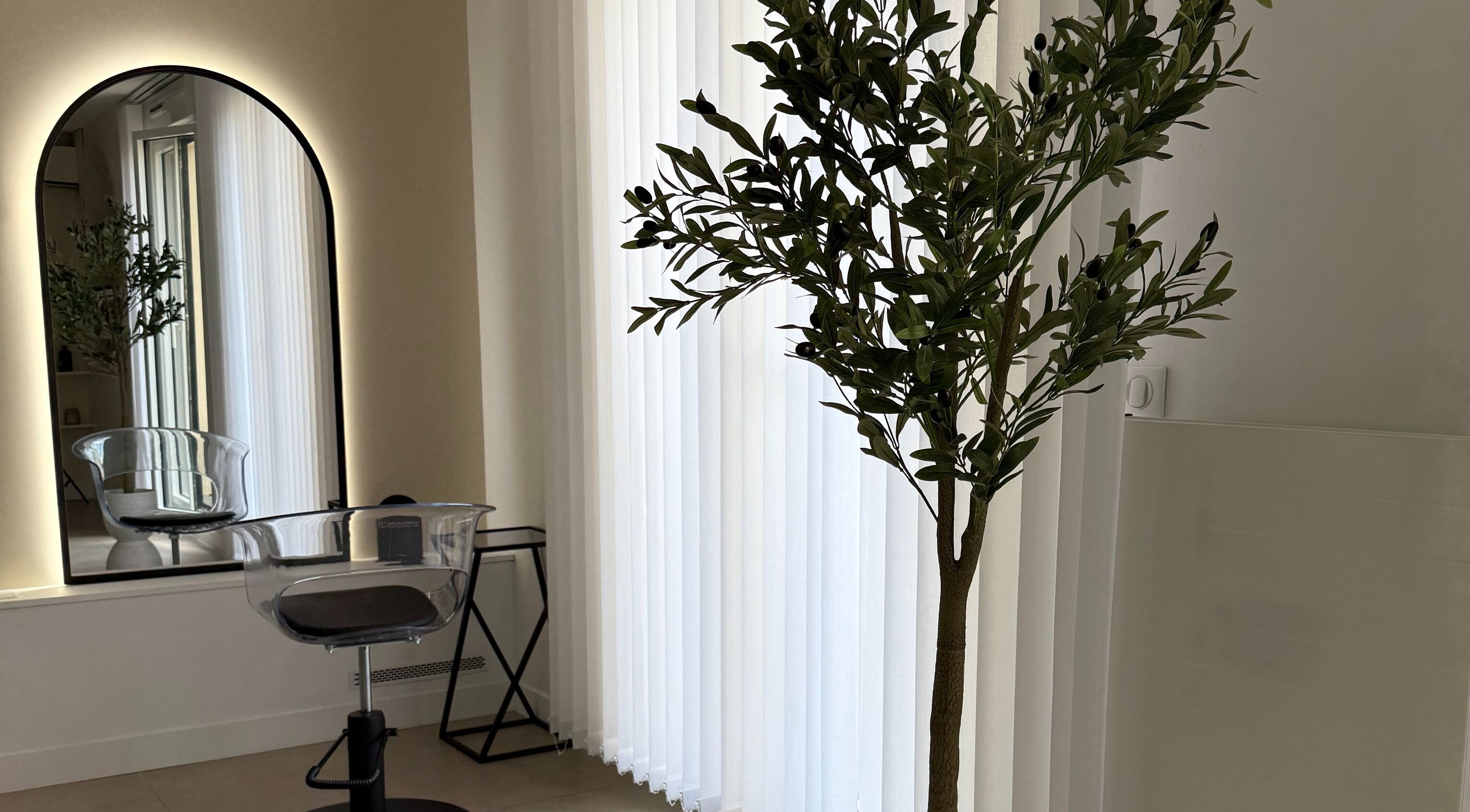 Intérieur élégant de STUDIO CAPILLAIRE à Suresnes, Île-de-France, FR avec miroir rétroéclairé et chaise moderne.