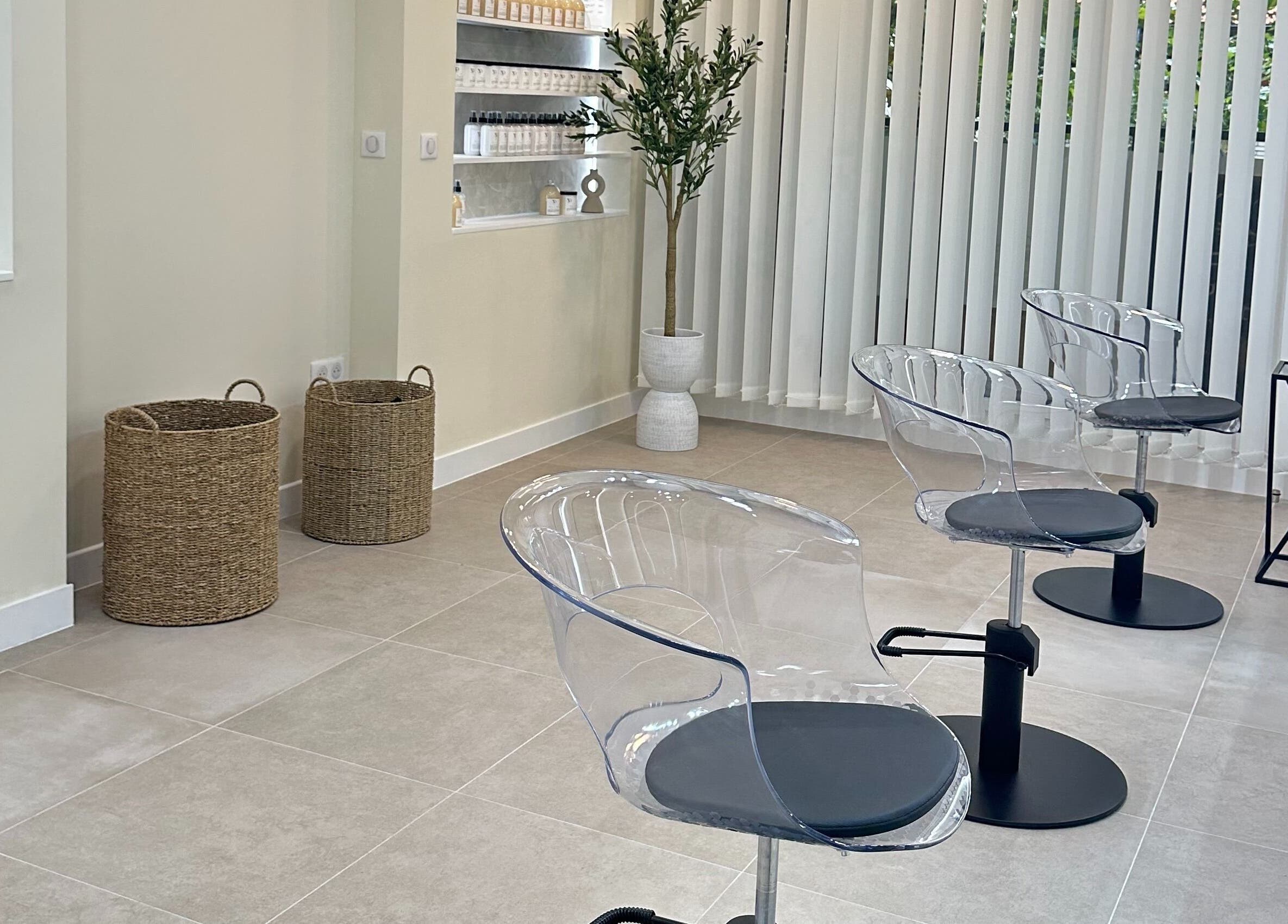 Intérieur moderne de STUDIO CAPILLAIRE à Suresnes, Île-de-France, FR avec chaises transparents et décoration raffinée.