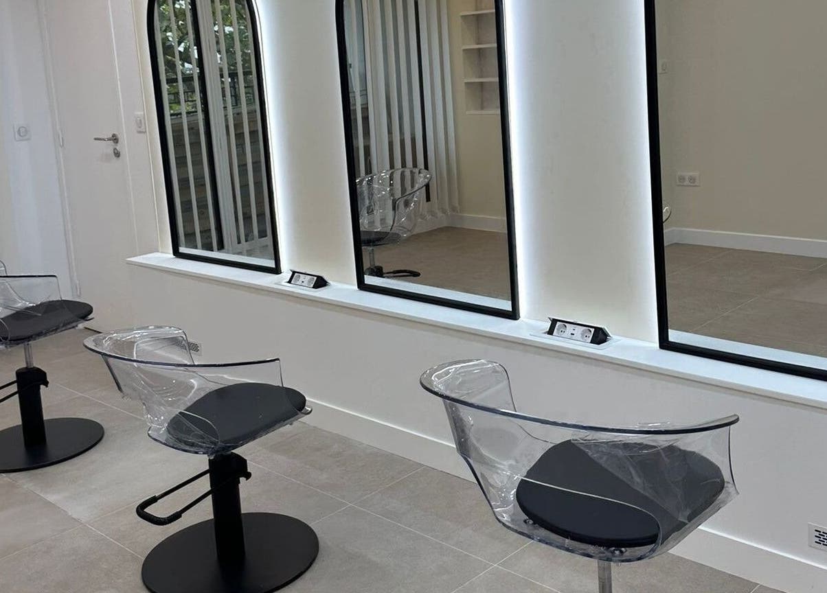 Chaises modernes chez STUDIO CAPILLAIRE à Suresnes, Île-de-france, FR, devant de grands miroirs lumineux.