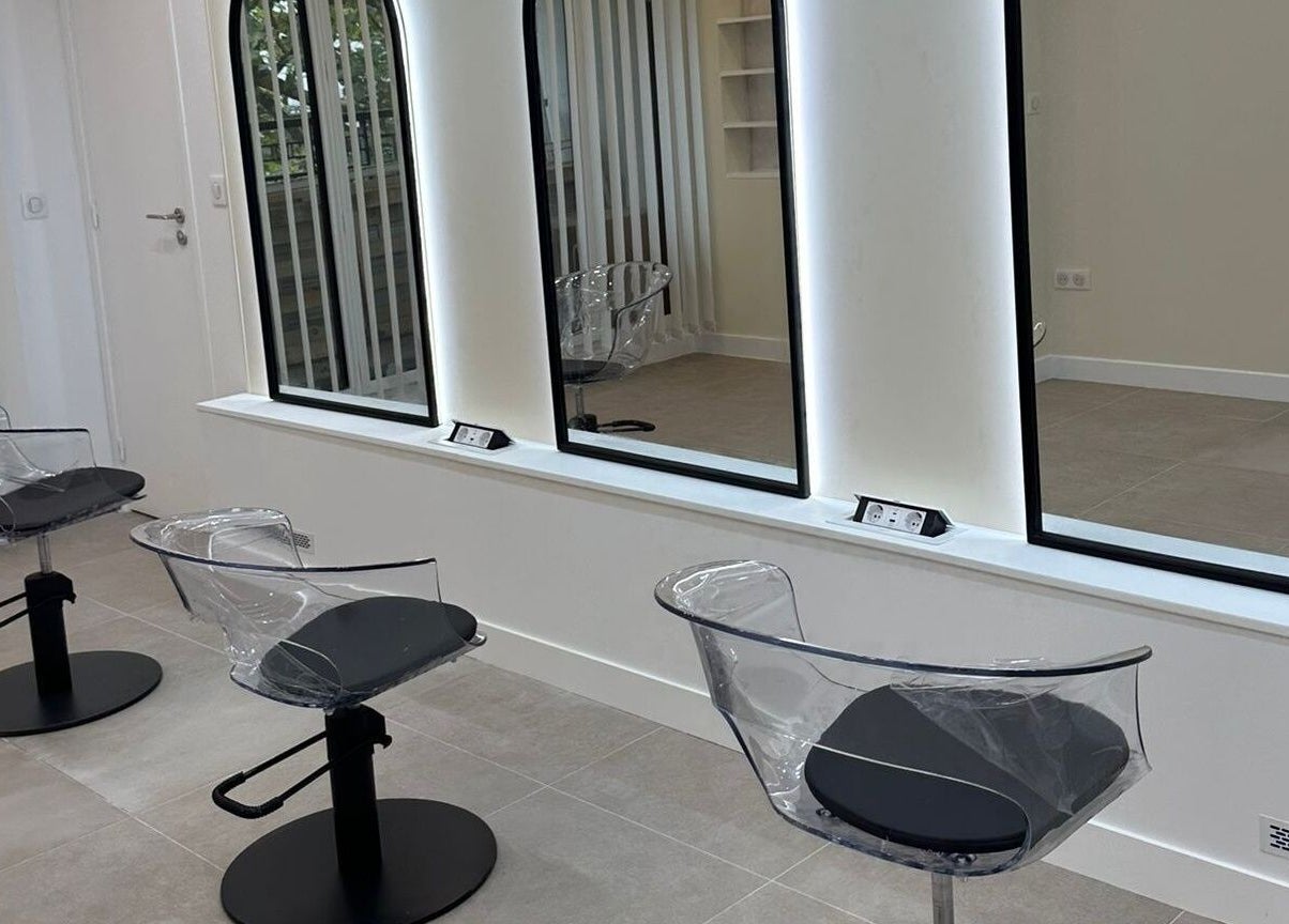 Chaises modernes chez STUDIO CAPILLAIRE à Suresnes, Île-de-france, FR, devant de grands miroirs lumineux.
