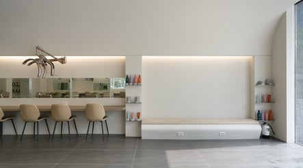 Modern interior of weneedblack forenadangsan salon with beige chairs and elegant decor, located in 서울특별시, 서울특별시, KR.