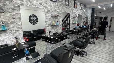 Stylish salon interior at braids by NicoleRose in Plymouth, England, GB, showcasing modern chairs and brick walls.
