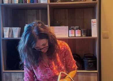 Interieur van Schoonheidsinstituut Amaris in Izegem, Vlaanderen, BE met vrouwelijke medewerker bij productenkast.