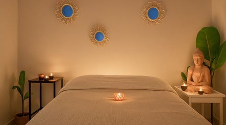 Salle de massage apaisante chez INDIANAYUR à Montpellier, Occitanie, FR, avec bougies et statue zen.